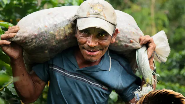 Cafenor coffee farmer with bag of coffee cherries