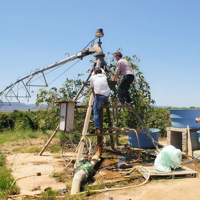 Three men ar fixing the irrigation system at a coffee farm in brazil