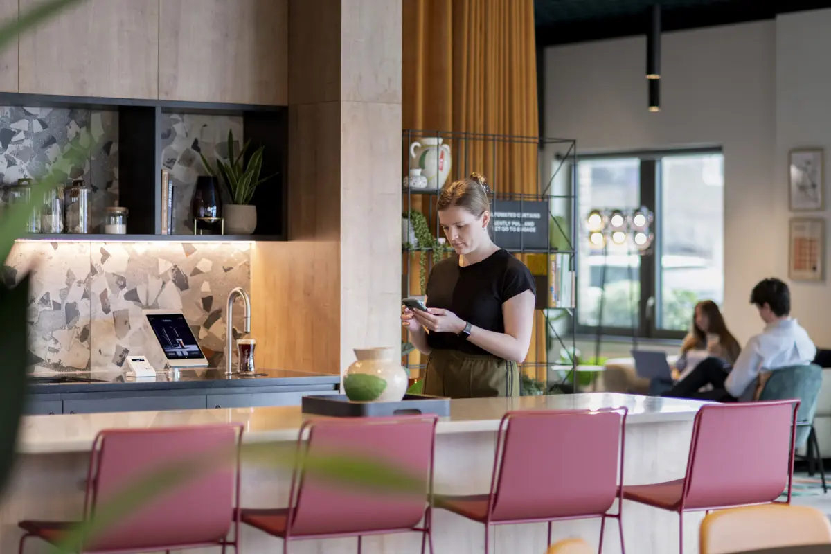 Wide shot in Uncle Southall showing a TopBrewer coffee machine and people in the background