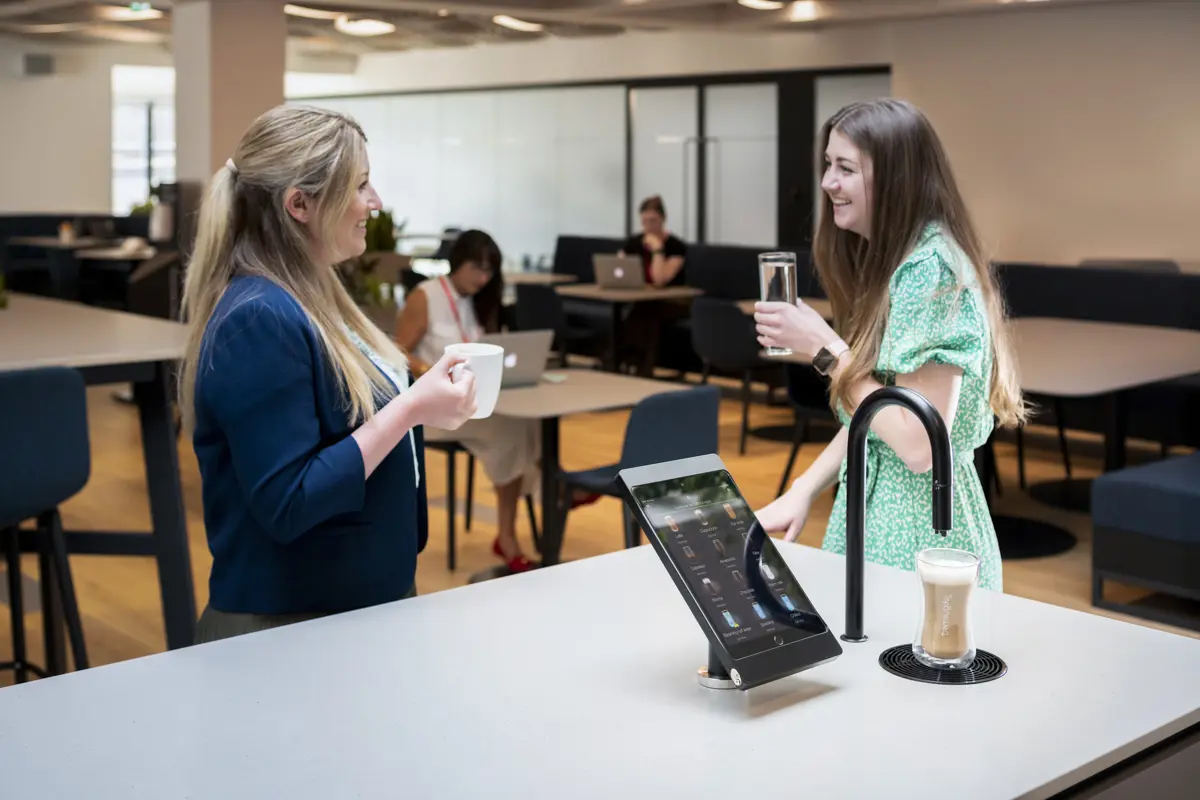 Image showing matte black TopBrewer with deluxe iPad holder and two people chatting next to it