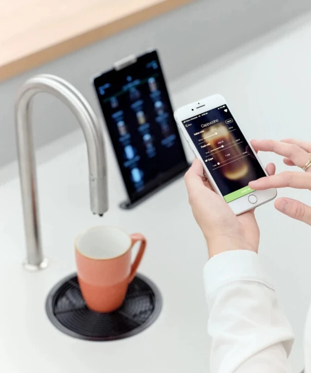 Woman brewing coffee with TopBrewer mobile app